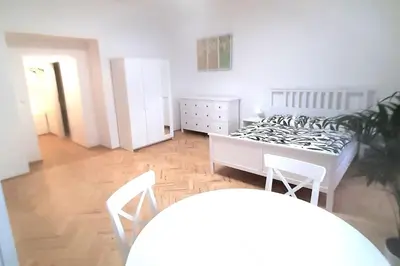 a bedroom with a bed and a table and chairs at Arbes apartman in Prague