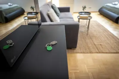 a living room with a couch and keys on a table at KIP Old Town Modern Apartment with Free Parking & AC in Prague