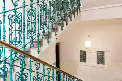 a staircase in a building with a green metal railing at KIP Old Town Modern Apartment with Free Parking & AC in Prague
