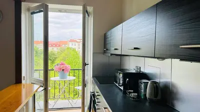 a kitchen with a black counter top and a window at Park View Apartment Anděl in Prague