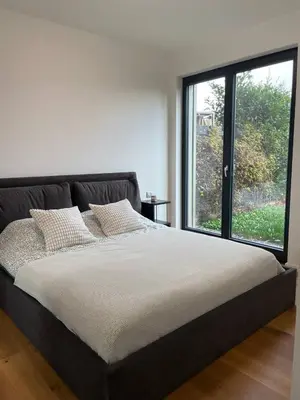 a large bed in a room with a large window at Serene & Private Garden Oasis in Prague