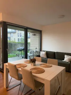 a living room with a table with chairs and a couch at Serene & Private Garden Oasis in Prague