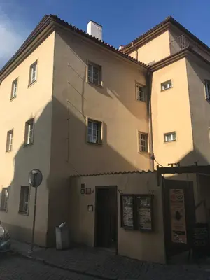 a large building with a shadow on the side of it at Apartments & Restaurant Tkalcovsky dvur in Prague