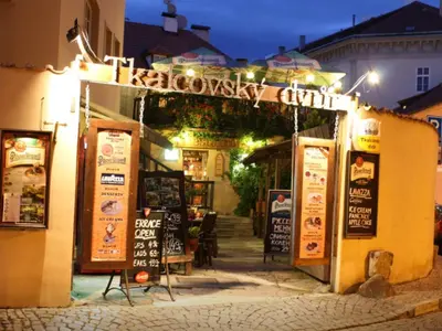 a restaurant with signs on the side of a building at Apartments & Restaurant Tkalcovsky dvur in Prague