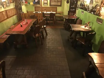 an empty restaurant with wooden tables and chairs at Apartments & Restaurant Tkalcovsky dvur in Prague