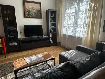 a living room with a couch and a tv at Apartments & Restaurant Tkalcovsky dvur in Prague