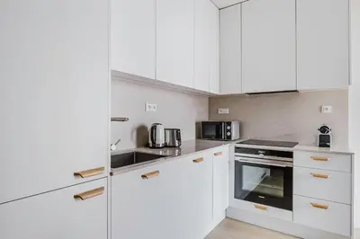 a white kitchen with white cabinets and appliances at Blueground Prague 7 furnished close to offices PRG-22 in Prague