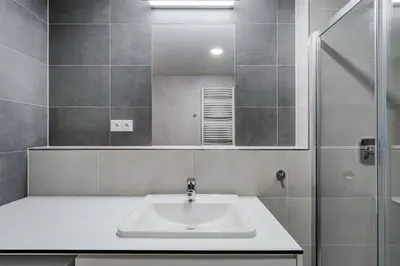 a bathroom with a sink and a shower and a mirror at Blueground Prague 7 furnished close to offices PRG-22 in Prague