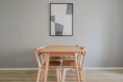 a wooden table and chairs in front of a wall at Blueground Prague 7 balcony Stromovka Park PRG-26 in Prague
