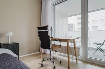 a bedroom with a desk and a chair and a window at Blueground Prague 7 balcony Stromovka Park PRG-26 in Prague