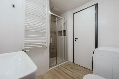 a white bathroom with a shower and a toilet at Blueground Prague 7 balcony Stromovka Park PRG-26 in Prague