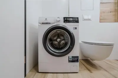 a washing machine in a bathroom next to a toilet at Blueground Prague 7 balcony Stromovka Park PRG-26 in Prague