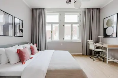a bedroom with a large white bed and a desk at Blueground Prague 2 renovated Náměstí Míru PRG-33 in Prague