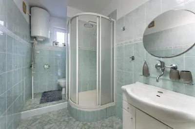 a bathroom with a shower and a sink and a mirror at Domeček na samotě in Terezín