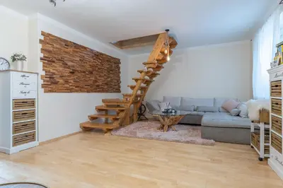 a living room with a staircase and a couch at Domeček na samotě in Terezín