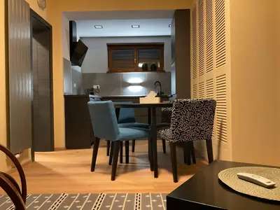 a kitchen and dining room with a table and chairs at Apartmán u lesa Nové Jirny in Nové Jirny