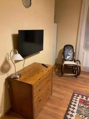a living room with a flat screen tv and a chair at Apartmán u lesa Nové Jirny in Nové Jirny