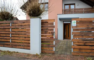 a wooden fence in front of a house at Apartmán u lesa Nové Jirny in Nové Jirny