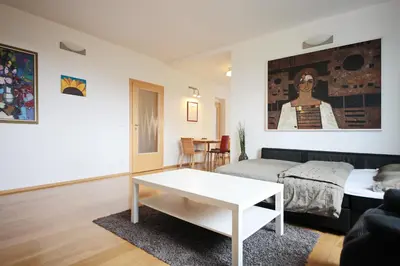 a living room with a bed and a table at Apartment Kosatcová in Prague