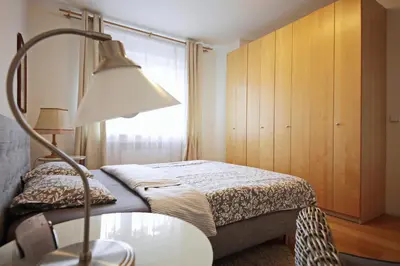 a bedroom with a bed and a table with a lamp at Apartment Kosatcová in Prague