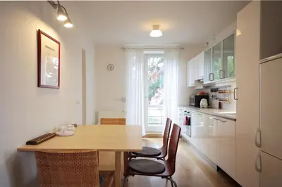 a kitchen with a wooden table and chairs at Apartment Kosatcová in Prague