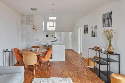 a kitchen and living room with a table and chairs at Prague Days - Deluxe Loft with View in Vinohrady in Prague