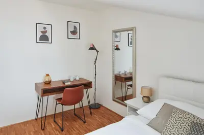 a bedroom with a desk and a bed and a mirror at Prague Days - Deluxe Loft with View in Vinohrady in Prague