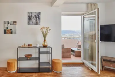 a living room with a television and a table and stool at Prague Days - Deluxe Loft with View in Vinohrady in Prague