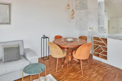 a table and chairs in a living room with a couch at Prague Days - Deluxe Loft with View in Vinohrady in Prague