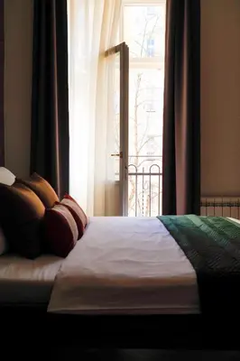 a bed with pillows sitting in front of a window at Rašínovo nábřeží - Riverside Residence in Prague