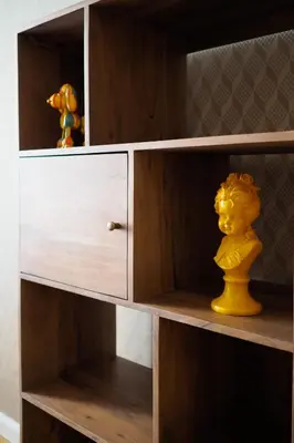 a wooden book shelf with a yellow toy in it at Rašínovo nábřeží - Riverside Residence in Prague