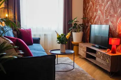 a living room with a couch and a tv at Rašínovo nábřeží - Riverside Residence in Prague