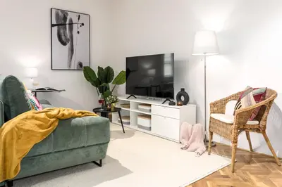 a living room with a green couch and a tv at Prague Days - One-bedroom Apartment with Balcony and Workspace in Vinohrady in Prague