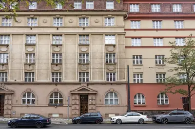 a large building with cars parked in front of it at Prague Days - One-bedroom Apartment with Balcony and Workspace in Vinohrady in Prague