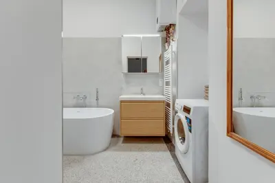 a bathroom with a sink and a washing machine in it at Prague Heart of Old Town Comfy Home 2BDR 2BATH in Prague