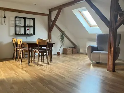a dining room with a table and chairs and a couch at Apartmán MUV in Mělník