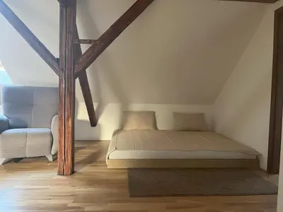 a bed in a room with wooden beams at Apartmán MUV in Mělník