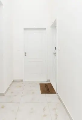 a white room with a door and a tile floor at Prague Old Town Residence in Prague