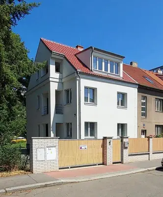 a white house with a fence in front of it at Spoon Apartment Prague 1A in Prague