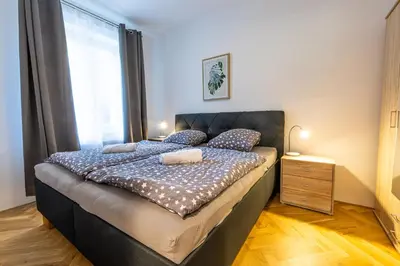 a bedroom with a bed with a large window at Spoon Apartment Prague 1A in Prague