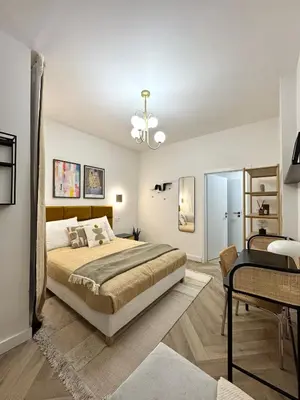 a bedroom with a large bed and a desk at Rentero National Theatre Apartment with 2 Bathrooms Prague City Center in Prague