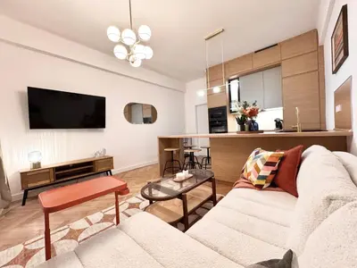 a living room with a white couch and a television at Rentero National Theatre Apartment with 2 Bathrooms Prague City Center in Prague