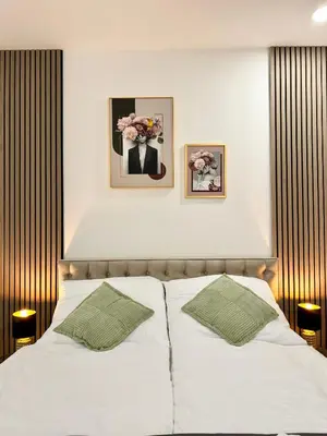 a bedroom with a white bed with two green pillows at Little Downtown Apartment in Prague