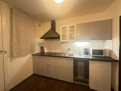 a kitchen with white cabinets and a microwave at Budget Dlouha Apartment in Prague