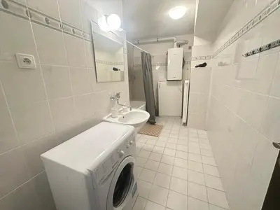 a bathroom with a washing machine and a sink at Budget Dlouha Apartment in Prague