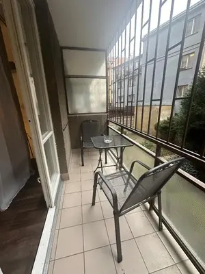 a balcony with a table and a chair in a building at Budget Dlouha Apartment in Prague