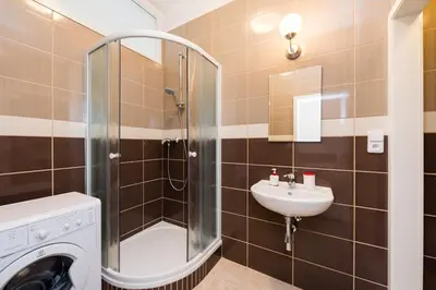 a bathroom with a washing machine and a sink at Affordable Stay Navratilova in Prague