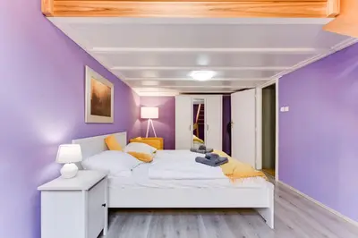 a bedroom with a white bed and purple walls at Place of Grace - 3 minutes from the Museum and Old Town in Prague