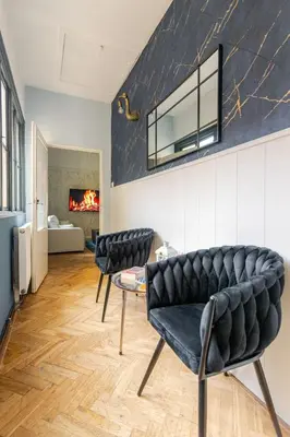 two black chairs in a living room with a fireplace at Place of Grace - 3 minutes from the Museum and Old Town in Prague