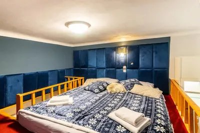 a bedroom with a large bed with blue walls at Place of Grace - 3 minutes from the Museum and Old Town in Prague